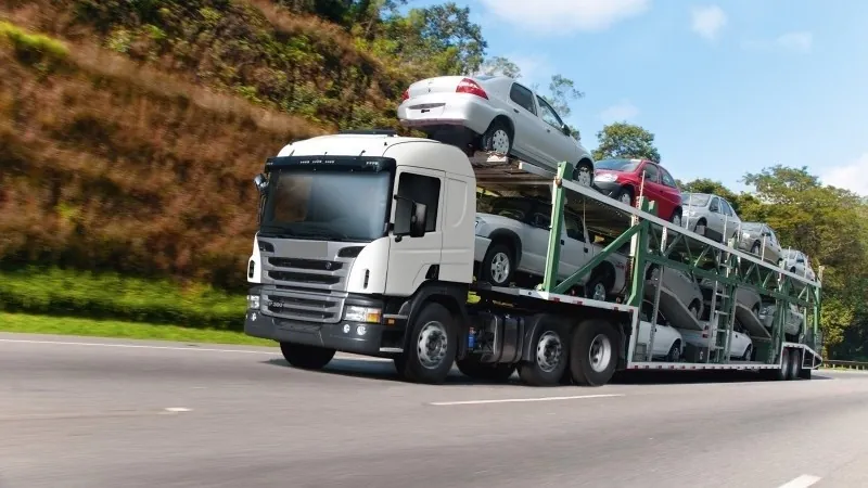 Caminhão cegonha carregado de veículos em rodovia